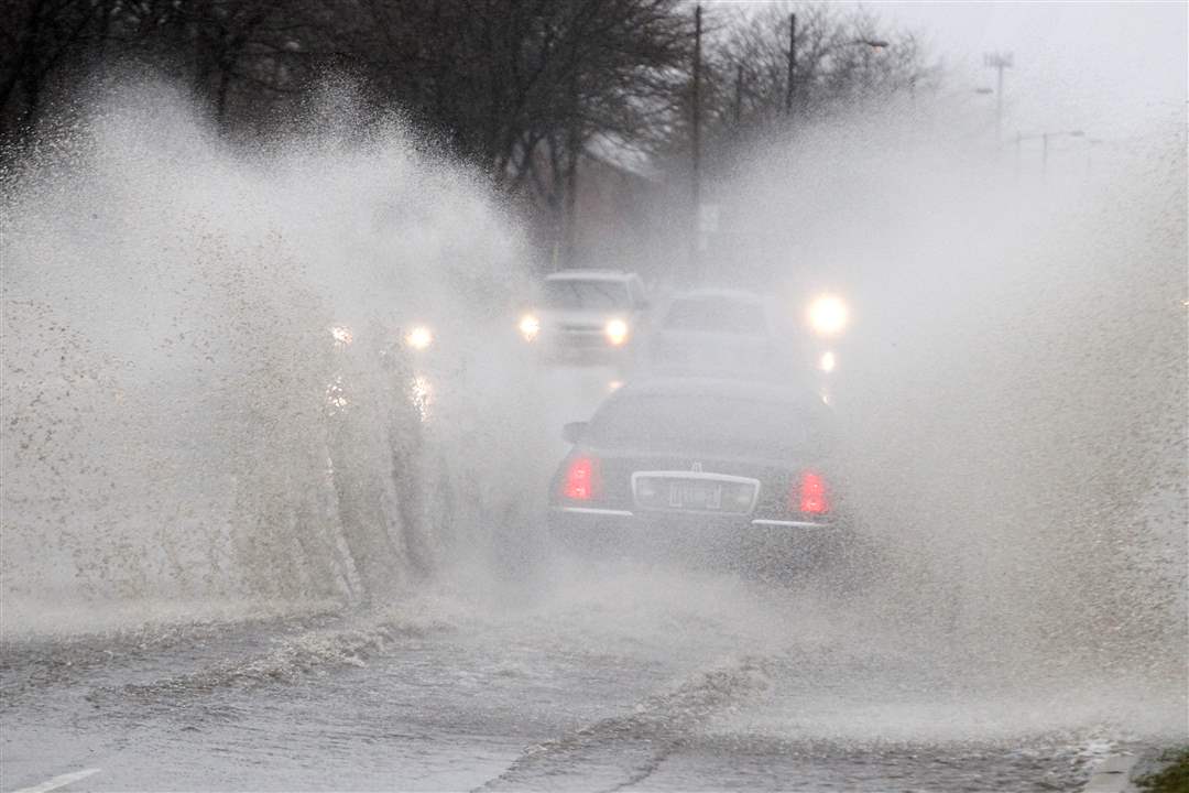 A-car-splashes-through-the-rain-on-Dorr-St-east-of-City-Park-Ave