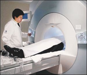 A technician prepares a patient for an MRI at the former Medical College
of Ohio. Steady increases nationwide in medical imaging services, as well as safety concerns, led insurers to require preauthorization.