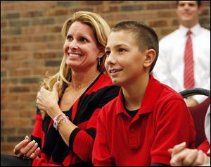 Urban Meyer’s wife, Shelley, and his son, Nathan, watch as he is introduced as the new Ohio State football coach.

