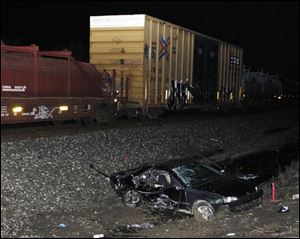 The wreckage of a car lies at the bottom of train tracks following a fatal train-car collision on Nadeau Road in Monroe, Mich.