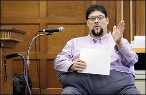 Geoffrey Dupuis holds a photograph of the scene as he testifies during his trial for the murder of Randall York.