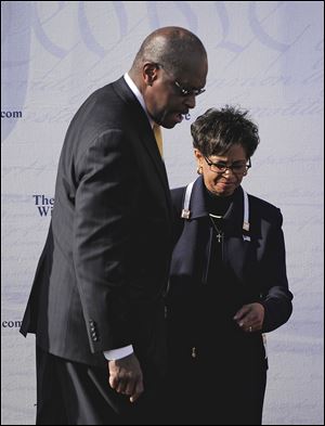 Herman Cain, left, steps off stage with his wife, Gloria, after he announced Saturday at an Atlanta rally that he was suspending his presidential campaign.