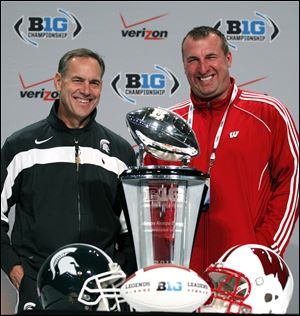 Michigan State coach Mark Dantonio, left, and Wisconsin head coach Bret Bielema pose with the Big Ten championship trophy during a news conference in Indianapolis, on Friday. Michigan State is scheduled to face Wisconsin in the Big Ten Championship game on Saturday.