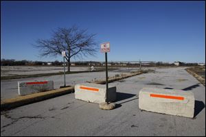 Cement blocks prevent cars from entering the parking lot of the former Southwyck Mall in Toledo.