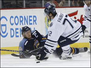Toledo Walleye player Kyle Rogers, 17, falls down as he passes the puck past Chicago Express player Pierre-Luc Faubert, 72, during the first period at the Huntington Center, Saturday.
