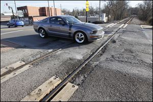 A car crosses the railroad tracks on Monroe Street, west of Main Street, in Sylvania.