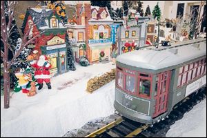 The model train pulls into a village visited by Santa.