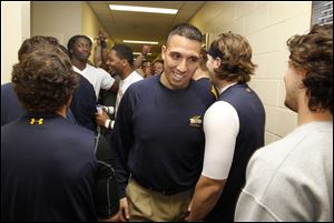 Newly named University of Toledo interim head football coach Matt Campbell, center, makes his way through UT football players in a hallway at the Larimer Athletic Complex on the UT campus in Toledo, Friday. 