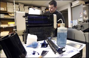 Brian Bishop cleans the offset press at the Copy Shop in Bowling Green. The business began at the start of the recession in 2008.