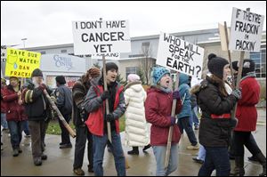 Anti-fracking protestors carry signs while protesting in front of The Covelli Center near downtown Youngstown, Ohio, where the Youngstown Ohio Utica & Natural Gas Conference & Expo took place.