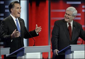 Republican contender Mitt Romney makes a point as Newt Gingrich listens during the GOP debate in Des Moines, the 12th since the campaign began. 