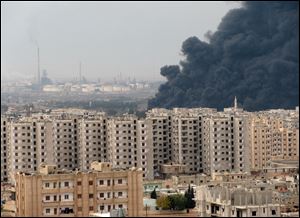 This photo released by the Syrian official news agency SANA, purports to show black smoke enveloping part of Homs, Syria.