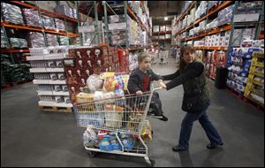In Portland, Ore., Tina VanPelt and her son, Soloman, 4, shop at a Costco store. Food and pharmaceutical prices are higher, but energy prices have held steady, keeping inflation in check. And a downward trend in unemployment applications suggests that companies are cutting fewer workers as the economy picks up.