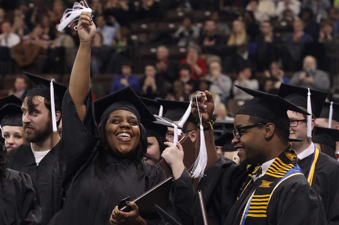 Graduates-Jamillah-Smith-2nd-from-right-and-Derris-Cameron-wave-their-tassels