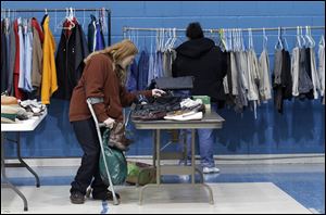 Shelly McCullough, a 29-year-old mother of three from Toledo who was disabled when she was 6 months old, chooses a pair of boots. She said she relies on Social Security and disability payments. 