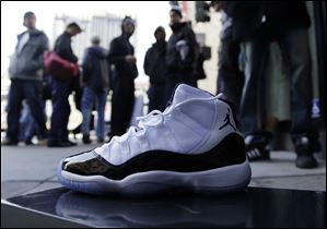 A newly-purchased Air Jordans sneaker is shown in front of a line of customers at the Nike Store at Union Square Friday.
