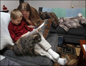Jesse Johnson, 6, gets homework help from his mom Dew Johnson at their new Locust St. home in Toledo, Ohio.