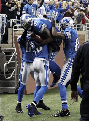 Detroit Lions wide receiver Calvin Johnson (81) is congratulated by teammates after his touchdown during the second quarter of an NFL football game against the San Diego Chargers in Detroit, Saturday.