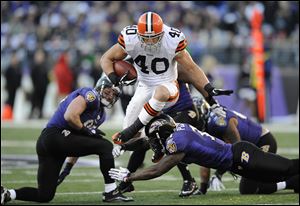 Browns running back Peyton Hillis (40) leaps over Ravens strong safety Bernard Pollard, bottom, in the second half of Saturday's game. Hillis had a season-high 112 yards rushing in the loss.