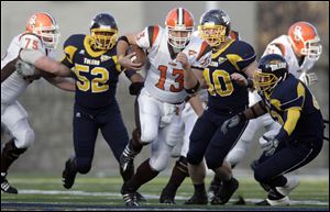 Bowling Green State University quarterback Tyler Sheehan, 13, runs past University of Toledo defenders Johnathan Lamb, 52, Alex Johnson, 40, and Archie Donald, 42.
