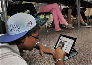 Jalen Daoust looks at photos from the 9/11 terrorist attack on his iPad during his social studies class at Maumee Valley Middle School, where 78 students and nine on the faculty and the staff received the electronic devices this year.