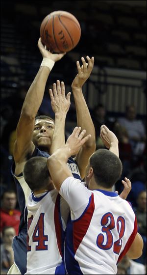 Marc Loving of St. John’s shoots over Trent Morrisey, left, and Nathan White of St. Francis. Loving, a junior, has committed to play at Ohio State.