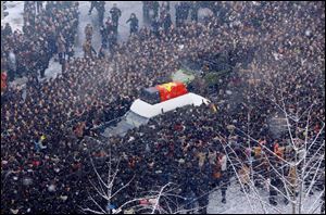 Mourners surround a hearse carrying the coffin of the late North Korean leader Kim Jong Il during his funeral procession Wednesday through the streets of Pyongyang, North Korea.