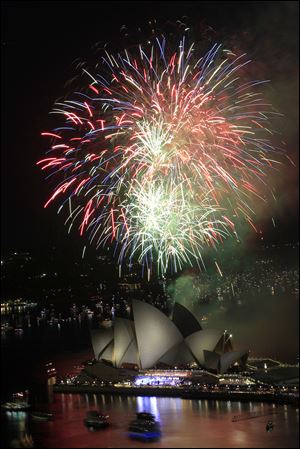 Fireworks burst over Sydney Opera House as New Year's celebrations begin in Sydney, Australia, Saturday.