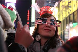 Wearing 2012 glasses and a Happy New Year headpiece, Bernadette Brandl smiles as she takes part in the New Year's Eve festivities in New York's Times Square Saturday. Brandl, who is originally from Austria, is currently living in Minnesota.