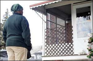 A neighbor looks at a memorial for Andrew Baker and Tanja Cathey, found slain at home at 2226 Sanford St.