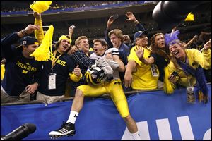 Michigan wide receiver Jordan Barpal (35) jumps into the stands and celebrates with fans after defeating Virginia Tech 23-20 in overtime of the Sugar Bowl NCAA college football game in New Orleans, Tuesday, Jan. 3, 2012. (AP Photo/Gerald Herbert)