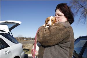 Open Arms Transport volunteer and Toledo Blade reporter Tanya Irwin holds one of the dogs she will help transport to Ontario. The group met  at 1122 Buck Rd. in Rossford, Ohio.