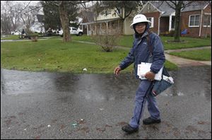 Postal worker Rolando Buno delivers mail in the rain Arpil 19, 2011, along Heatherdowns Boulevard in Toledo. Bruno has braved the elements to deliver mail for 17 years.