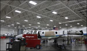 The number of overhead lights was reduced at the Toledo Jet Center, but the hangars where staff work on
aircraft are just as bright, officials at the facility on the grounds of Toledo Express report.