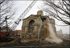 A wrecking ball knocks out the upper southwest corner of the Seneca County courthouse Monday afternoon.