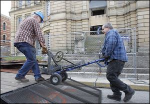 David Kreais, owner of Antiques Warehouse, left, and his brother Ken Kreais, load the mechanism Seneca County Courthouse clock onto a trailer. The pair were salvaging items from the courthouse before demolition.