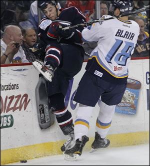 Toledo's Ryan Blair checks South Carolina's Joe Pereira into the boards during the second period at the Huntington Center. The Walleye held leads of 1-0 and 2-1 in the first period but could not snap their losing streak.