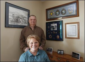A collection of Alaska State Trooper memorabilia provides a backdrop for Tim Hunyor, and his wife, Sandy Gable Hunyor, in their Portage home. Mr. Hunyor retired after nearly 30 years service.
