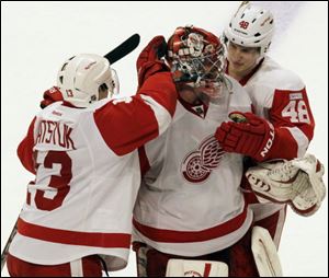 Detroit Red Wings goalie Ty Conklin (29) celebrates with Pavel Datsyuk (13) and Cory Emmerton (48) after they defeated the Chicago Blackhawks 3-2 in an NHL hockey game in Chicago, Sunday.