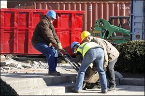 Workers remove the one of the cornerstones of the Seneca County Courthouse on the second day of its demolition Tuesday.