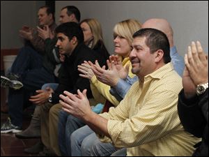Ray Campos, front, and other supporters applaud P.J. Kapfhammer as he is sworn into his new school board post. 