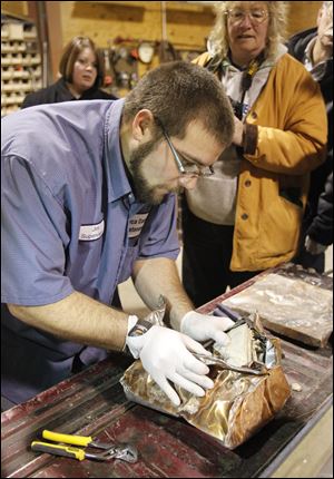 Jim Barth, Seneca County maintenance supervisor, opens the crushed time capsule inside the county garage. Because the box was damaged in the demolition, there was little ceremony. 'I guess the decision was made for us,' Commissioner Jeff Wagner said.