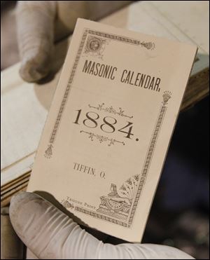 Among the items in the time capsule were a Masonic calendar from 1884, left. Other items included newspapers, letters, notices from utility firms and cards from local banks, a city of Tiffin directory, and an almanac.