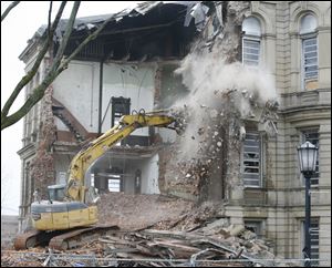 An excavator claws into the 1884 Seneca County Courthouse as demolition continues. The copper-clad capsule was exposed after the cornerstone was pulled loose Thursday and dropped, causing the lid of the box to come off. 