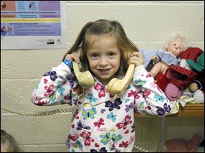 Kindergartner Madi Hammer uses her imagination and a couple of telephones for an activity during recess at Solomon Lutheran School in Woodville. The school opened its doors Jan. 20, 1862.