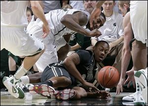 Michigan State's Branden Dawson, top, and Purdue's John Hart and Robbie Hummel, right, vie for the ball during the first half of an NCAA college basketball game Saturday in East Lansing, Mich. Michigan State won 83-58. 