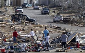 Residents comb through debris looking for personal belongings after a severe storm and possible tornado ripped through the Georgebrook subdivision area  in Trussville, Ala.