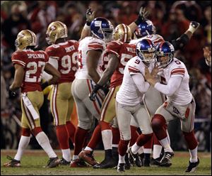 New York Giants kicker Lawrence Tynes (9) celebrates with holder  Steve Weatherford (5) after kicking the game-winning field goal during overtime of the NFC Championship NFL football game against the San Francisco 49ers Sunday, Jan. 22, 2012, in San Francisco. The Giants won 20-17 to advance to Super Bowl XLVI. (AP Photo/David J. Phillip)