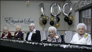 With balloons behind them touting the occasion, from left, Heloise Warrington, Doris Mohr, Glenford Rupp, Elizabeth 'Betty' Rose, and Lorina Arps celebrate their 100th birthdays at the Elizabeth Scott Community in Maumee. 