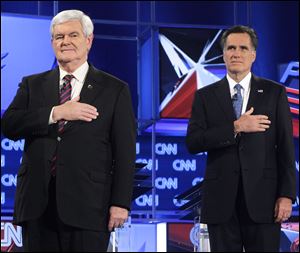Republican presidential candidates Newt Gingrich, left, and Mitt Romney stand during the National Anthem before the Republican presidential candidates debate Thursday at the University of South Florida in Jacksonville, Fla.